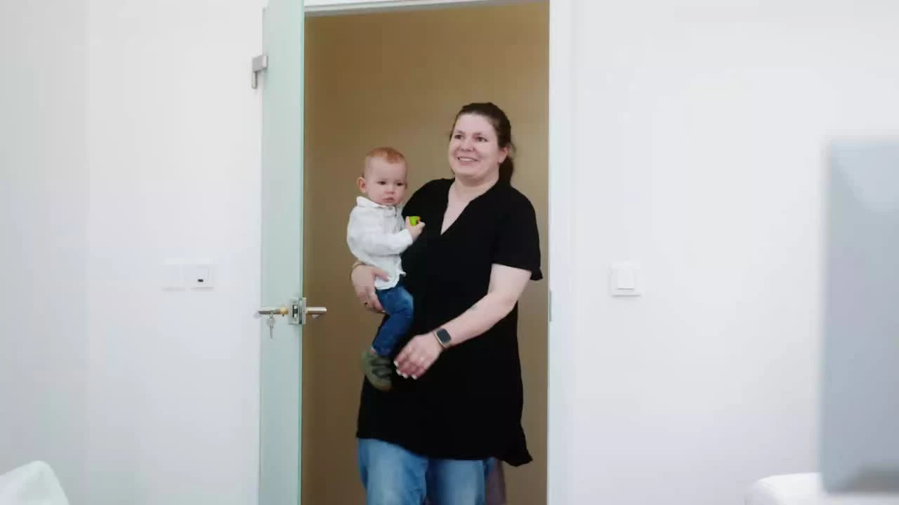 Maminka s malým dítětem v náručí přichází do ordinace