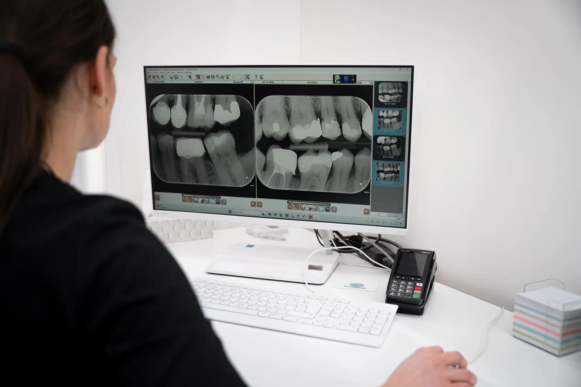 Lékařka hodnotí rentgenové snímky chrupu na monitoru